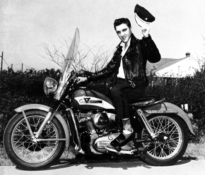 Elvis Presley on a motorbike, wearing a leather jacket